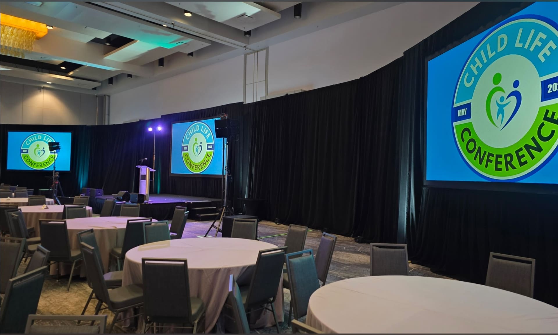 Conference stage with branded screens and round table seating
