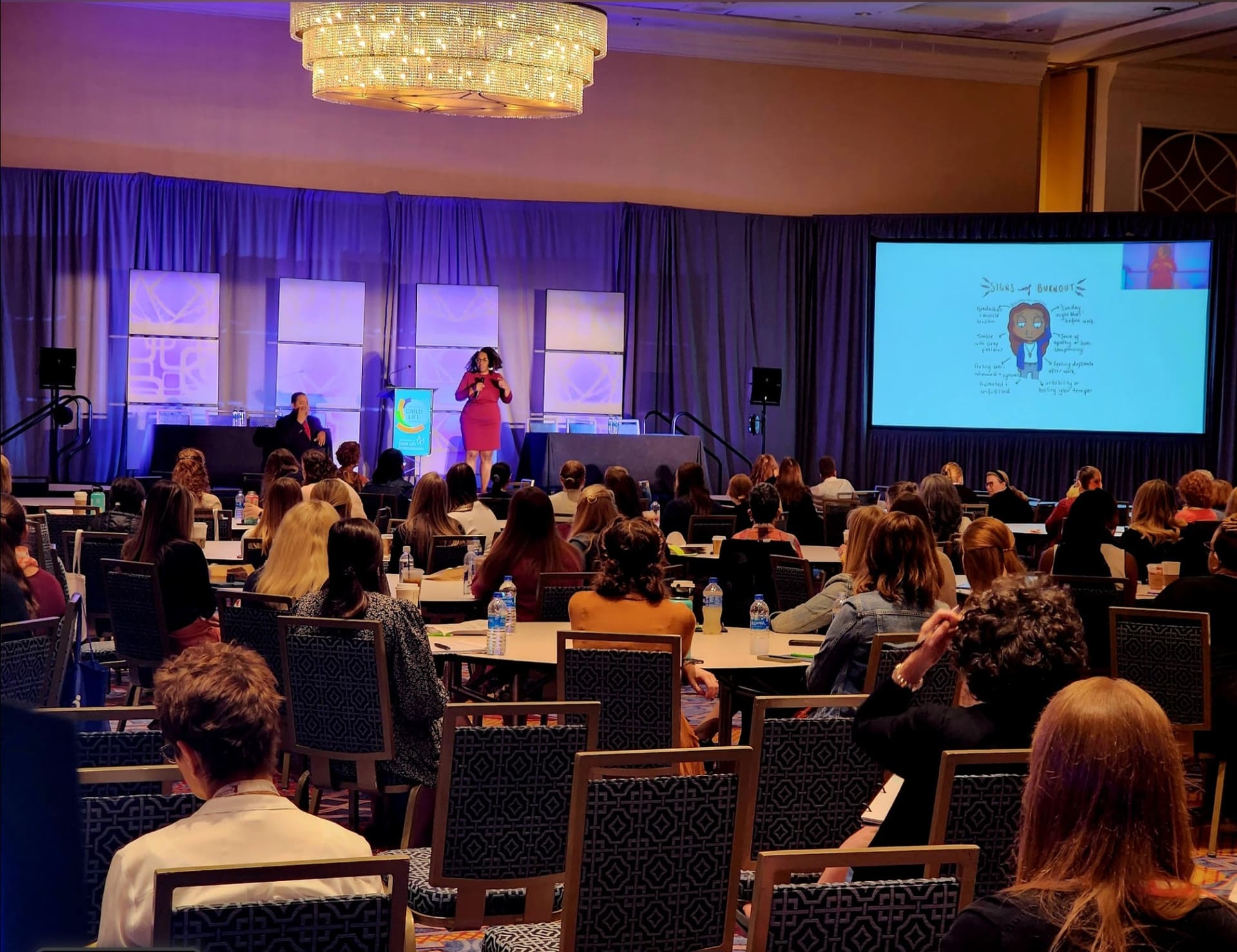 Keynote speaker presenting to a packed conference audience