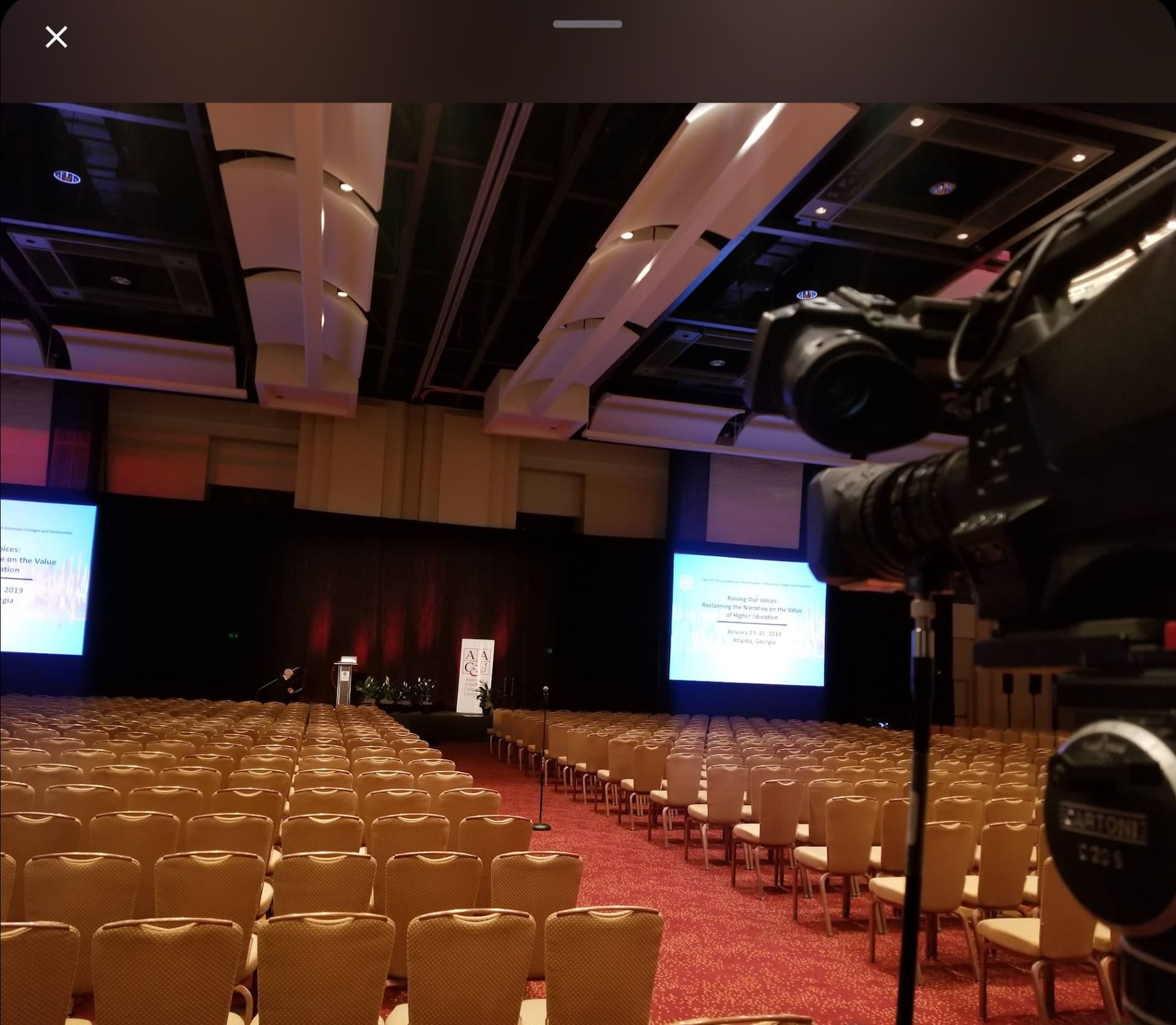Professional video camera capturing a large conference event